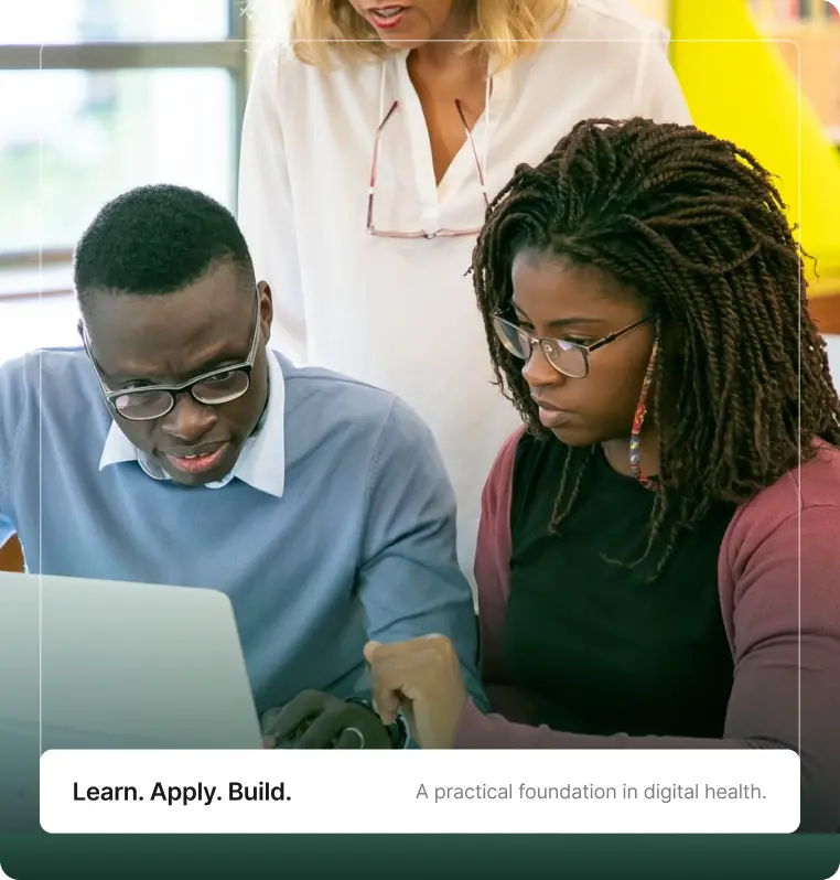 Learners working through a practical laptop exercise with a tutor